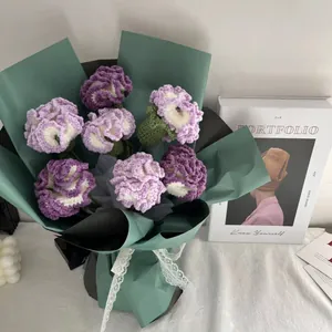 Dettaglio di un bouquet di garofani all'uncinetto viola con nastro di pizzo bianco