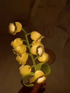 Close-up of handmade lily of the valley crochet night light with warm LED glow