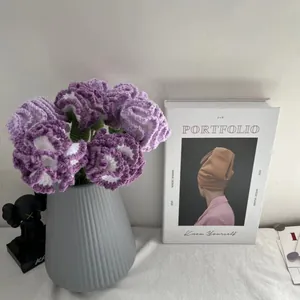 Dettaglio di garofani lavorati a maglia viola in un vaso grigio per decorazione casa