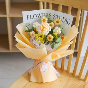 Detail of hand-knitted flower bouquet with crochet daisies and roses in gift wrap