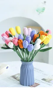 Detail of colorful hand-knitted tulip bouquet in a blue geometric vase for home decor