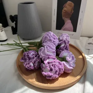 Dettaglio di garofani fatti a mano all'uncinetto in viola e bianco, ideali per la casa