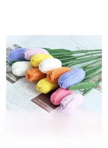 Close-up of handmade knitted tulips in various colors on vintage newspaper background