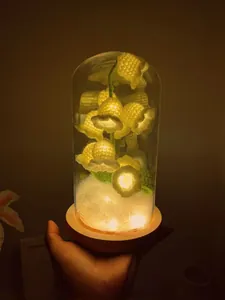 Detailed view of hand-crocheted lily of the valley lamp in a glass dome with LED