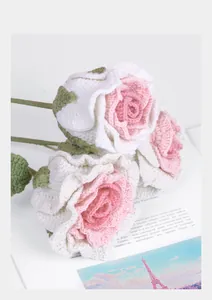 Detail of three handmade crochet roses with soft white and pink gradient petals