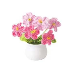 Handmade crochet pink forget-me-not potted flower plant with a white ceramic base