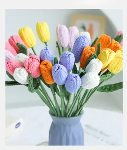 Detail of colorful handmade knitted tulips in a ceramic vase with vivid crochet textures