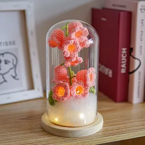Detailed view of pink crocheted lily of the valley lamp in a glass dome with LED lighting