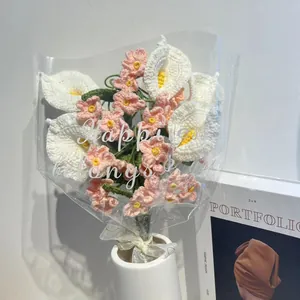 Ramo de calas blancas y flores rosas de ganchillo hecho a mano en un jarrón de cerámica blanca