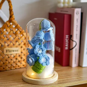 Hand-knitted blue lily of the valley lamp in a glass dome with a warm LED wooden base