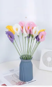 Detail of colorful hand-knitted calla lily bouquet in a modern geometric matte vase