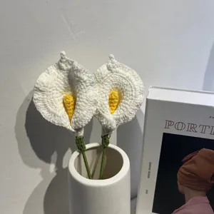 Detalle de dos calas hechas a mano a ganchillo en un jarrón blanco para decorar