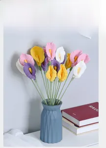 Detail of colorful crochet calla lily bouquet in a blue textured vase for home decor
