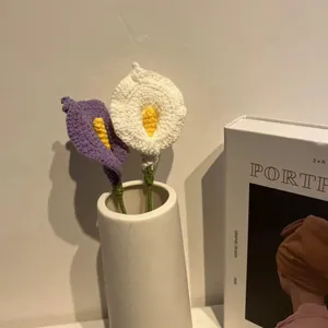 Detalle de lirios cala tejidos a mano en color violeta y blanco en jarrón blanco