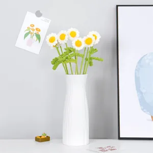Handmade crochet daisy bouquet in a white textured ceramic vase for home desk decor