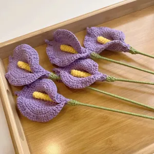 Cinco calas moradas tejidas a mano en bandeja de madera para decorar el hogar