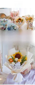 Detail of hand-knitted crochet flower bouquet with sunflowers and daisy in gift wrap