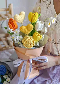 Close-up of handmade crochet heart bouquet with orange tulips in soft pink gift wrap