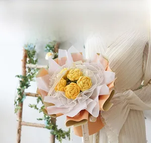 Detail of handcrafted crochet rose bouquet with orange wrapping and Love ribbon