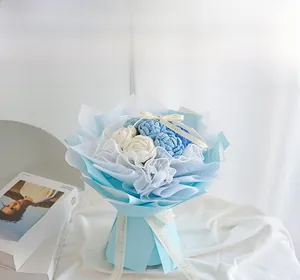Close-up of handmade crochet blue and white roses in delicate translucent gift wrapping