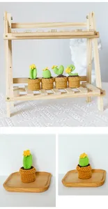 Detailed view of four handmade crochet mini cactus potted plants on a wooden display shelf