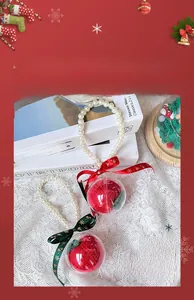 Detail of Christmas apple ornaments in clear balls with pearls and snowflake ribbons