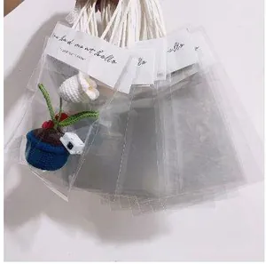 Detailansicht klarer Geschenktüten mit weißem Papierkopf und geflochtenen Griffen in Fächerform