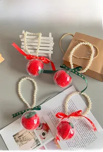 Detail of Christmas crochet apple ornaments with pearl handle and festive snowflake ribbon
