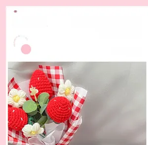 Détail d'un bouquet de fraises au crochet fait main avec fleurs blanches et papier