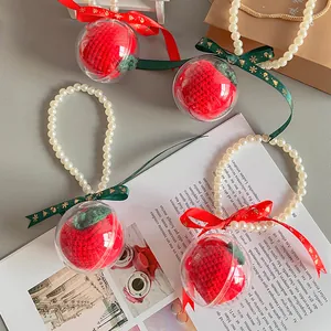 Set of four handmade crochet Christmas apple ornaments in pearls and ribbon packaging