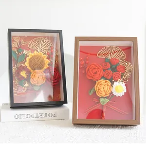 Detail of handmade crochet flower photo frame with sunflowers and roses on lace