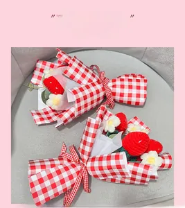 Détail d'un bouquet de fleurs au crochet avec des fraises rouges et des marguerites