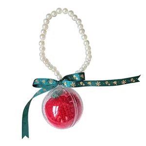 Christmas knitted apple in a transparent ball with pearl handle and green ribbon bow