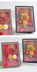 Detailed view of handmade crochet flowers including roses and sunflowers in a shadow box