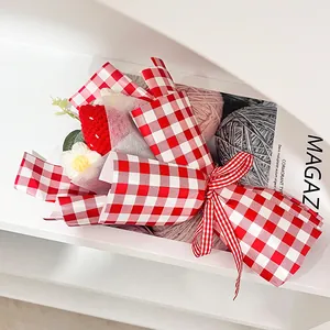 Bouquet de fraises et marguerites au crochet fait main dans un emballage à carreaux