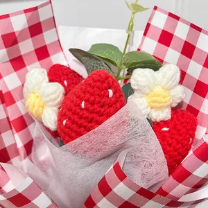 Bouquet de fraises et fleurs au crochet fait main dans un emballage à carreaux rouges
