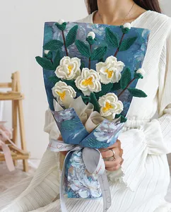 Bouquet de camélias blancs tricotés à la main dans un emballage bleu style peinture