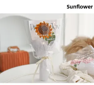Detail of hand-crocheted orange sunflower bouquet in elegant translucent gift wrap