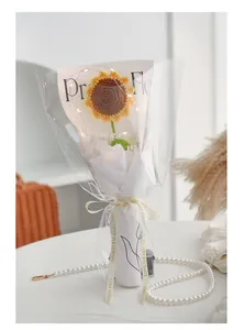 Detail of hand-crocheted sunflower bouquet with warm LED lights and LOVE IS ETERNAL ribbon