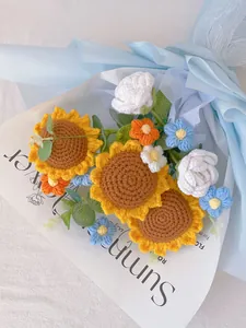 Close-up of handmade crochet flower bouquet with sunflowers and roses in blue wrapping