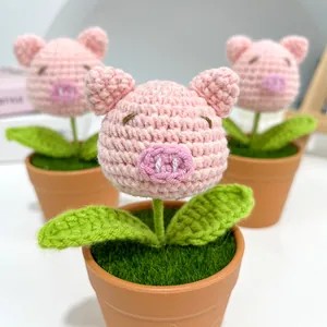 Handmade crochet pink pig potted plant with green leaves in a brown pot as a creative gift