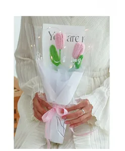 Detail of pink hand-knitted tulip bouquet with LED lights and silk ribbon packaging