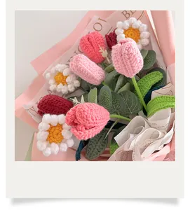 Detailed view of handmade crochet tulip and daisy bouquet in pink floral wrapping paper