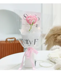 Detail of hand-knitted pink flower with LED lights and Just For You ribbon packaging