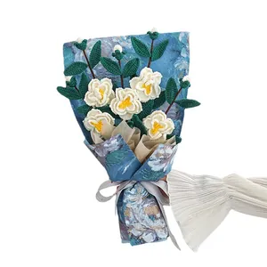 Bouquet de camélias fait main au crochet dans un emballage bleu pour cadeau de fête