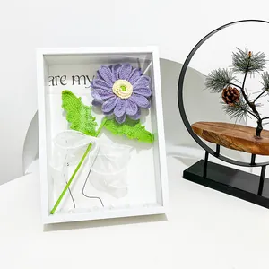Detail of 3D frame with hand-knitted purple daisy and pearl decorative accents