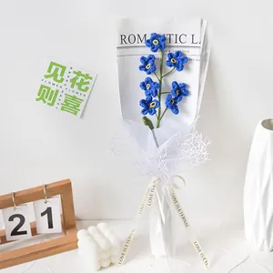 Handmade crochet blue forget-me-not flower bouquet in elegant gift packaging with white ribbon