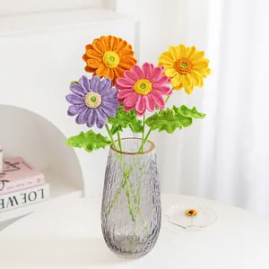 Handmade crochet flowers bouquet including daisies and sunflower in grey glass vase