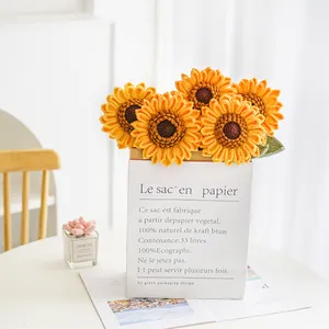 Detalle de ramo de girasoles hechos a mano a ganchillo en bolsa de papel blanca