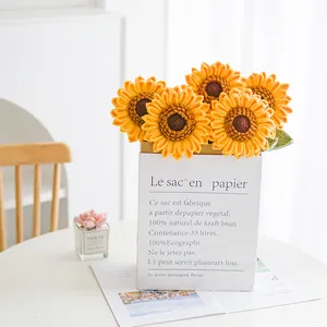 Ramo de girasoles tejido a mano en bolsa de papel con detalles realistas de ganchillo